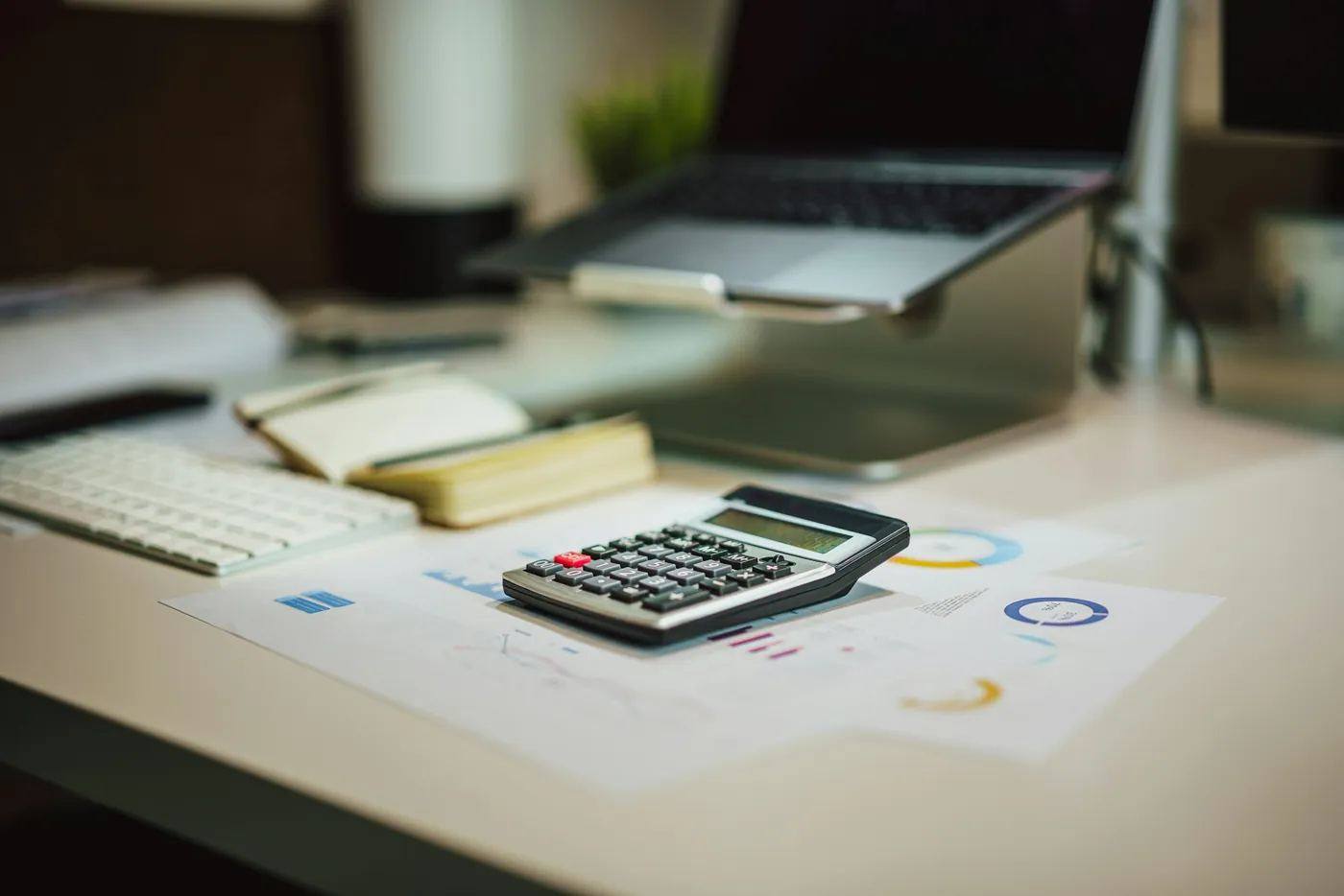 Calculatrice, carnet et ordinateur portable sur un bureau