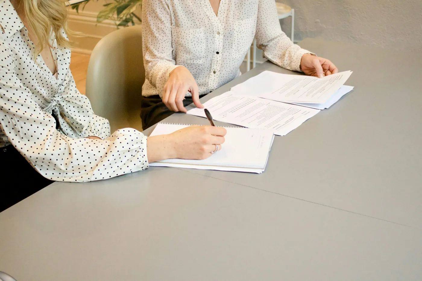 Une cliente signe des documents à une table